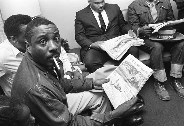 Chicago comedian Dick Gregory, wearing denim jacket and western attire, reads a Memphis newspaper as he waits in the administrator's office, June 7, 1966 at William F. Bowld Hospital in Memphis for word of James Meredith's condition. Gregory arrived in Memphis from Chicago with the announced purpose of taking up Meredith's Memphis-to-Jackson, Miss., march at the point, where Meredith was shot on Monday afternoon. (Photo by Charles Kelly/AP Photo)