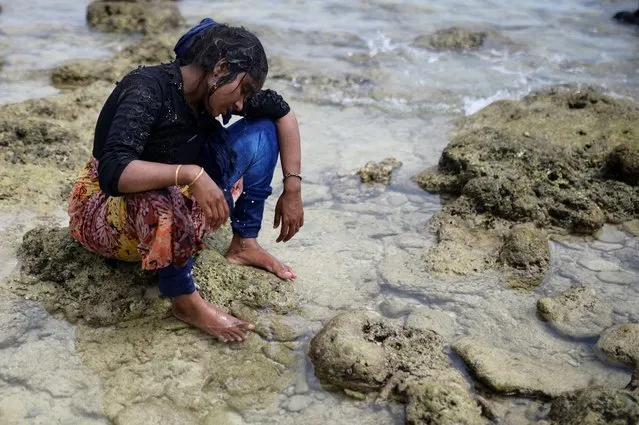 Rohingya Muslim woman rests after landing on a beach in Sabang, Aceh province, Indonesia on November 22, 2023. (Photo by Riska Munawarah/Reuters)