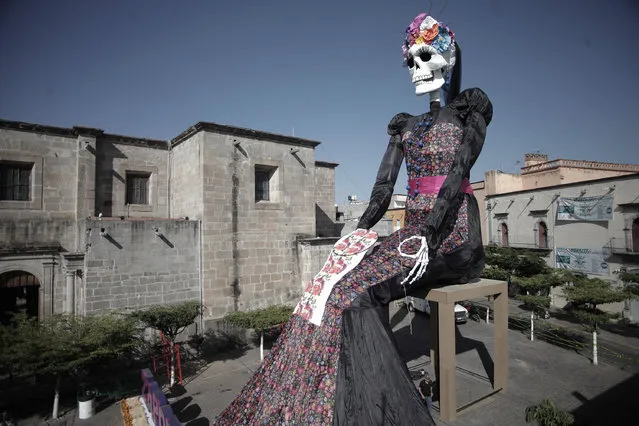 General view of a large sculpture of a Catrina which is 18 meters high and 1 kilometer of fabric rests in the streets of Zapotlanejo town during the “Festival de los Altares” as part of the preparations for “Day Of The Dead” in Mexico on October 29, 2022 in Zapotlanejo, Mexico.  Considered one of the most representative traditions, the day of the dead takes place during the first two days of November. Mexicans prepare to have full celebrations after two years of restrictions due to the coronavirus pandemic. (Photo by Leonardo Alvarez Hernandez/Getty Images)