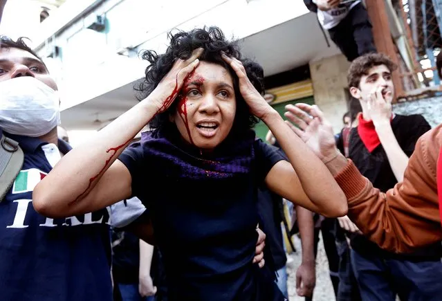 A woman is injured during a protest at a military parade marking Brazil's Independence Day in Rio de Janeiro, Brazil, Saturday, September 7, 2013. Brazilians are protesting corruption and poor public services. (Photo by Silvia Izquierdo/AP Photo)