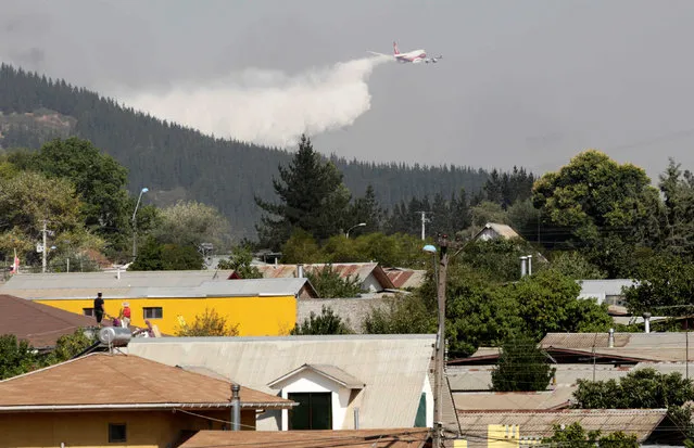 A Boeing 747-400 Super Tanker from the U.S. drops water to extinguish a forest fire in the town of Hualane in the Maule region, south of Chile, January 25, 2017. (Photo by Pablo Sanhueza/Reuters)