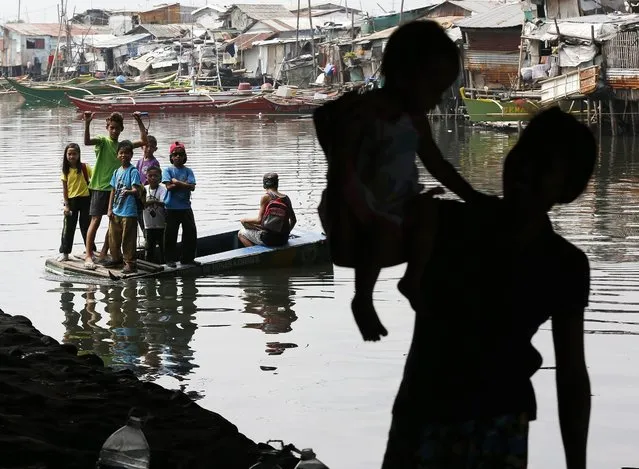 Filipino school children ride on a makeshift boat as they cross a river in Bacoor, Cavite, Philippines, 11 March 2016. According to Department of Education Secretary Armin Luistro, the government is introducing a story book on disaster preparedness to enhance the awareness and response capabilities of school children to natural and man-made disasters. The book entitled as “What Happens in Disasters” contains a compilation of real accounts of children who survived calamities in the country, Luistro added. (Photo by Francis R. Malasig/EPA)