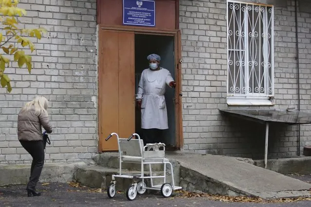 A medical worker stands at an enter of a hospital treating COVID-19 patients in Donetsk, controlled by Russia-backed separatists, Ukraine, Thursday, October 14, 2021. The Russia-backed separatist authorities in eastern Ukraine are reporting the largest spike in new coronavirus infections since the start of the pandemic, saying the health care system has been overwhelmed. The health authorities in the Donetsk region of 2.2 million reported over 1000 new confirmed infections and about hundred coronavirus deaths in the past 24 hours. (Photo by Alexei Alexandrov/AP Photo)