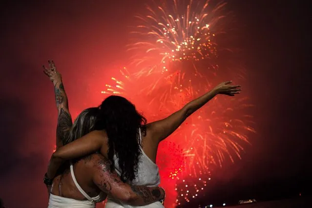 People celebrate as they watch the traditional New Year's fireworks from the water at Copacabana Beach in Rio de Janeiro, Brazil, on January 1, 2024. (Photo by Tercio Teixeira/AFP Photo)