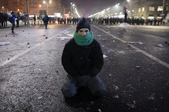 A protestor sits on the ground following scuffles between protestors and Romanian police at a demonstration in Bucharest, Romania, February 1, 2017. (Photo by Octav Ganea/Reuters/Inquam Photos)