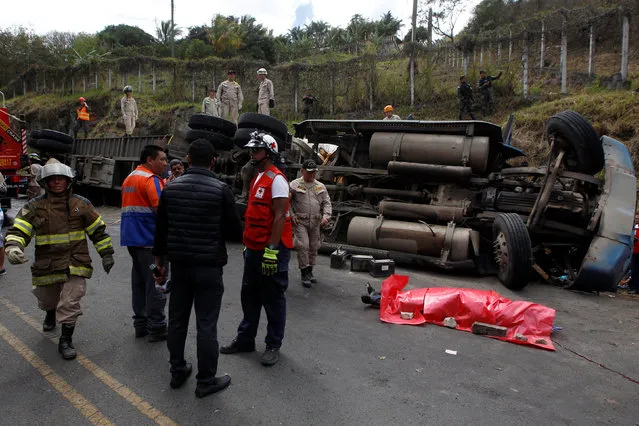 Rescue workers and members of the Red Cross stand next to a dead body after a crash between a bus and a truck on the outskirts of Tegucigalpa, Honduras, February 5, 2017. (Photo by Jorge Cabrera/Reuters)
