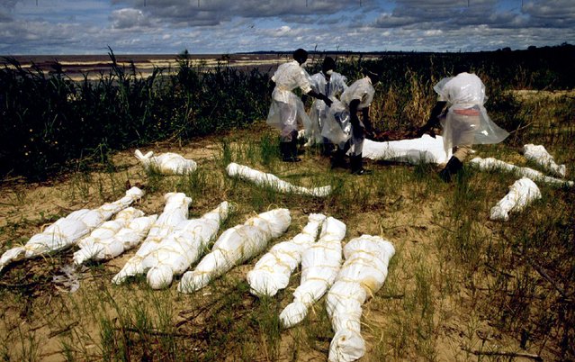 Ugandan fishermen pile up corpses for burial at Kasensero village 130 miles (208 kilometres) southwest of Kampala, Uganda May 20, 1994. The bodies were carried by Akagera river from Rwanda into Lake Victoria. (Photo by Reuters/Stringer)
