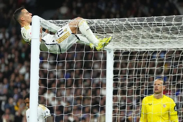 Real Madrid's Lucas Vazquez hangs from the crossbar during a Spanish La Liga soccer match between Real Madrid and Sevilla at the Santiago Bernabeu stadium in Madrid, Spain, Sunday, February 25, 2024. (Photo by Manu Fernandez/AP Photo)