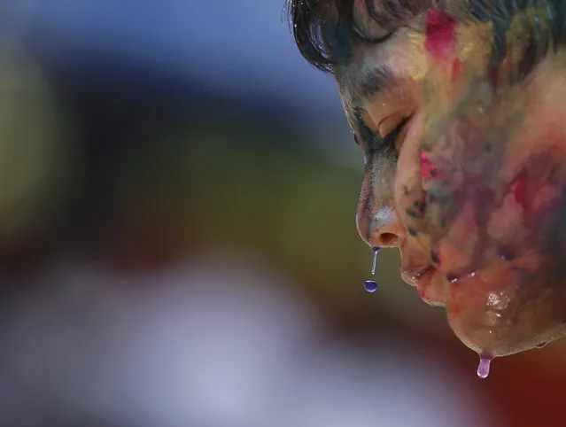 Myanmar Hindu boy smeared in colors as he takes part the Holi festival celebrations in Yangon, Myanmar, 23 March 2016. Holi is celebrated at the end of the winter season on the last full moon day of the lunar month Phalguna (February or March) in Hindu calendar which usually falls in the later part of February or March and is celebrated by people throwing colored powder and colored water at each other. (Photo by Lynn Bo Bo/EPA)