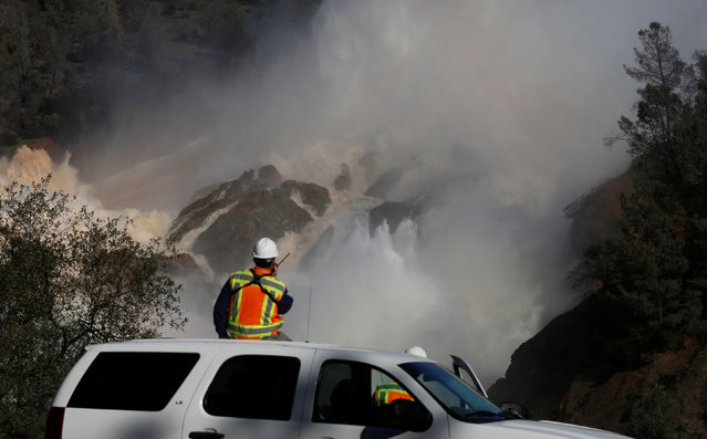 Staff with the California Department of Water Resources watch as water is released from the Lake Oroville Dam after an evacuation was ordered for communities downstream from the dam in Oroville, California, U.S., February 14, 2017. (Photo by Jim Urquhart/Reuters)