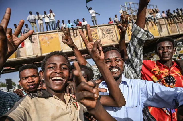 Sudanese protesters flash the V for victory sign during a sit-in outside the army headquarters in the capital Khartoum on April 29, 2019. Sudan's army rulers and protest leaders have offered different visions for a joint council, a military spokesman said today, expressing hope that a final structure of the body would be decided soon. (Photo by Ozan Kose/AFP Photo)