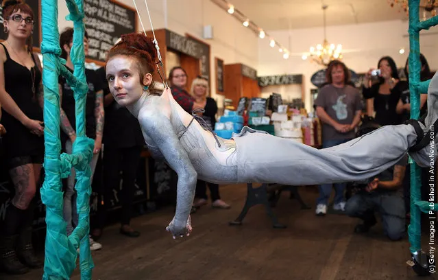 Alice Newstead inspects shark hooks that she had pierced into her skin during a demonstration against the shark fin trade