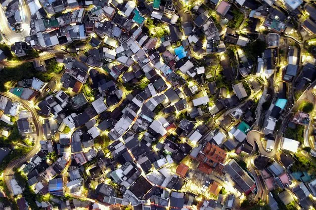 This aerial view shows a mountain village of Jioufen township, a tourist landmark in New Taipei City, northern Taiwan, on October 26, 2021. (Photo by Sam Yeh/AFP Photo)