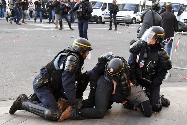 Anti- riot police officers detain a protester during scuffles within a demonstration against police brutality on February 18, 2017 on the place de la Republique in Paris, following the alleged rape of a black youth, identified only as Theo, with a police baton, an incident that has sparked 10 nights of rioting and more than 200 arrests The injuries sustained by Theo during a stop- and- search operation on February 2 in the suburb of Aulnay- sous- Bois have sparked clashes with police and arson attacks across the impoverished, ethnically- mixed housing estates that ring the French capital. One officer has been charged with rape and the three others with assault. (Photo by Alain Jocard/AFP Photo)