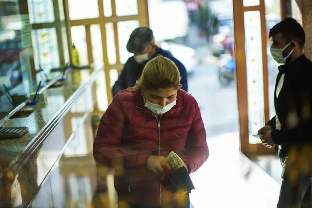 A woman holdsUS dollars notes after exchanging Turkish liras in a money exchange office in Istanbul, Turkey, Thursday, November 11, 2021. (Photo by Francisco Seco/AP Photo)