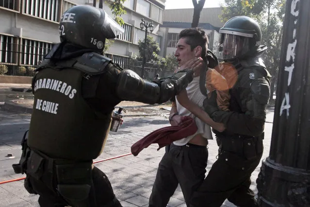 A protester is detained by the police during clashes during a student demonstration in Santiago, Chile, Thursday, May 14, 2015. (Photo by Luis Hidalgo/AP Photo)