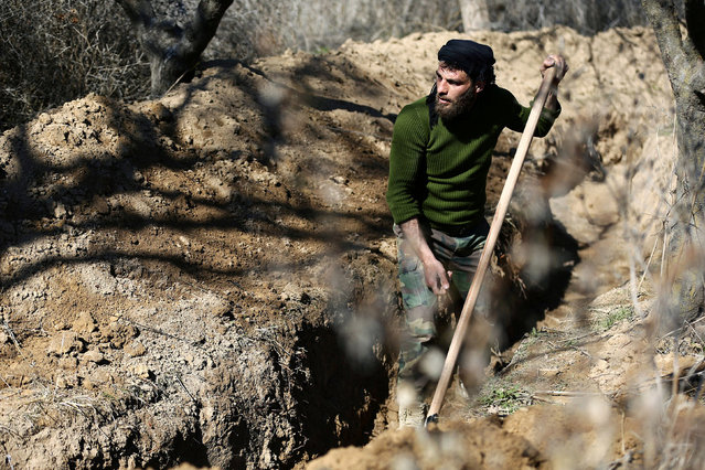 A fighter from the Free Syrian Army's Al Majd Brigades digs a trench in the rebel held besieged area of al-Marj in the Eastern Ghouta of Damascus, Syria February 18, 2017. (Photo by Bassam Khabieh/Reuters)