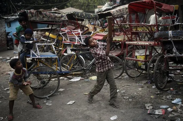 Children play cricket in front of parked rickshaws in the old quarters of Delhi, India March 31, 2016. (Photo by Anindito Mukherjee/Reuters)