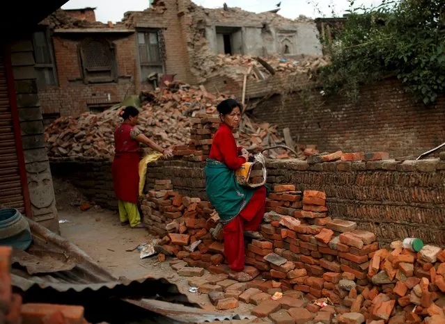 Women prepare to carry bricks from a collapsed house on the outskirts of Kathmandu, Nepal, May 15, 2015. (Photo by Ahmad Masood/Reuters)