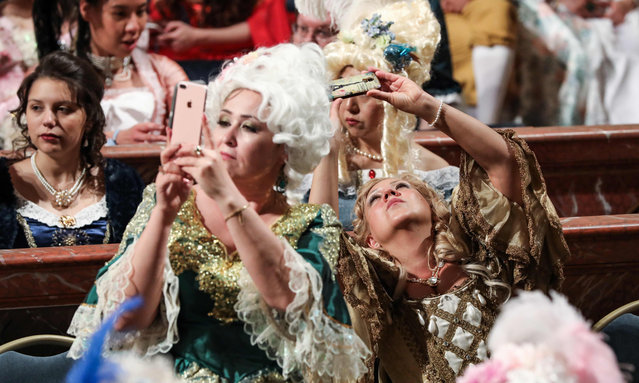 People dressed in period costumes sits in the royal opera as they take part in the “Fetes Galantes” fancy dress evening in the Chateau de Versailles, France on May 27, 2019. (Photo by Ludovic Marin/AFP Photo)