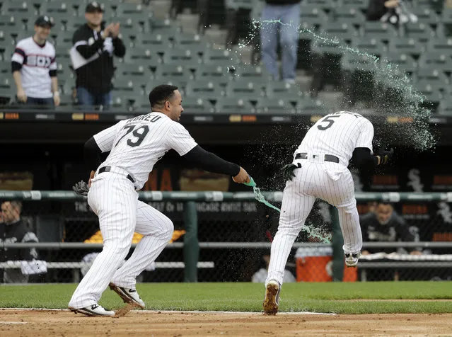 Chicago White Sox's Jose Abreu, left, splashes teammate Yolmer Sanchez after Sanchez's RBI-single off Kansas City Royals relief pitcher Kevin McCarthy won the contest in the ninth inning of a baseball game that was suspended due to rain the previous day, in Chicago, Tuesday, May 28, 2019. The White Sox won 2-1. (Photo by Charles Rex Arbogast/AP Photo)