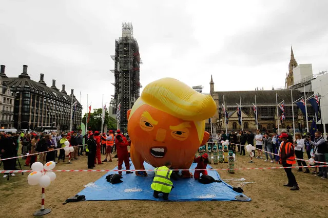 Anti-Trump demonstrators inflate a giant balloon depicting US President Donald Trump as an orange baby in Parliament Square in London on June 4, 2019, on the second day of Trump's three-day State Visit to the UK. US President Donald Trump turns from pomp and ceremony to politics and business on Tuesday as he meets Prime Minister Theresa May on the second day of a state visit expected to be accompanied by mass protests. (Photo by Tolga Akmen/AFP Photo)