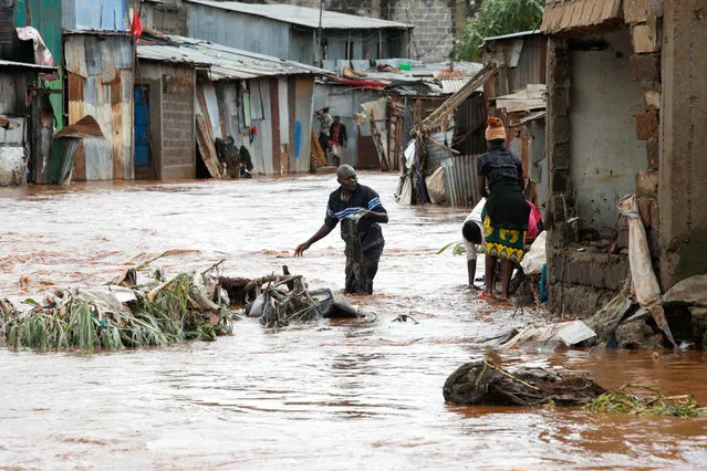 Residents wade through flood waters as they recover their belongings after the Nairobi river burst its banks within the Mathare valley settlement in Nairobi, Kenya on April 24, 2024. (Photo by Monicah Mwangi/Reuters)