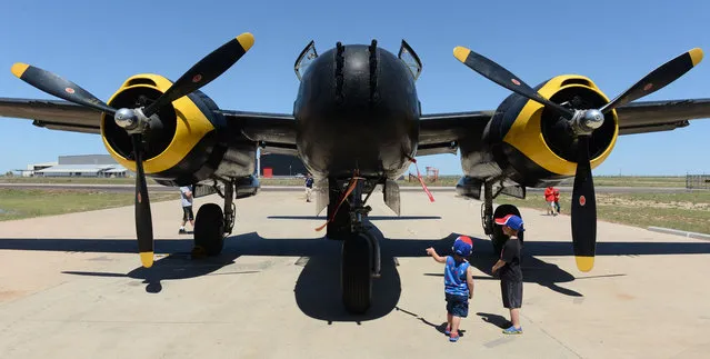 Phillip Williams, left, and Finlay Patterson, both of Odessa, Texas, look the B-26 aircraft on display during the Memorial Day observance at Midland International Air and Spaceport, Monday, May 25, 2015, in Midland, Texas. (Photo by Mark Sterkel/Odessa American via AP Photo)