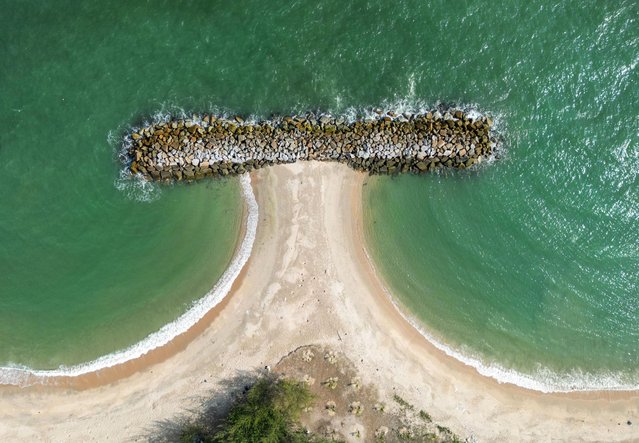 This aerial picture taken on April 20, 2024 shows a breakwater installed to prevent coastal erosion along the Saeng Chan beach in Thailand's Rayong province. Breakwaters are offshore concrete walls installed to reduce the erosive and damaging effects of strong waves out at sea. (Photo by Amaury Paul/AFP Photo)