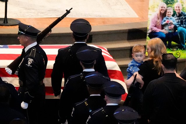 Ashley Eyer, wife and son Andrew watch during a memorial service for Officer Joshua Eyer, Friday, May 3, 2024, in Charlotte, N.C. Police in North Carolina say a shootout that killed Eyer and wounded and killed other officers began as officers approached a home to serve a felony warrant on Monday. (Photo by Chris Carlson/AP Photo)