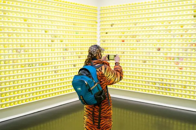 A visitor views some of the 12,000 tennis balls comprising “Mayfair Tennis Ball Exchange” by artist David Shrigley, at the Stephen Friedman Gallery, in London on Thursday, January 6, 2022. Visitors are invited to bring in an old tennis ball to swap with one of the new ones, creating a gradually evolving artwork. (Photo by Dominic Lipinski/PA Images via Getty Images)