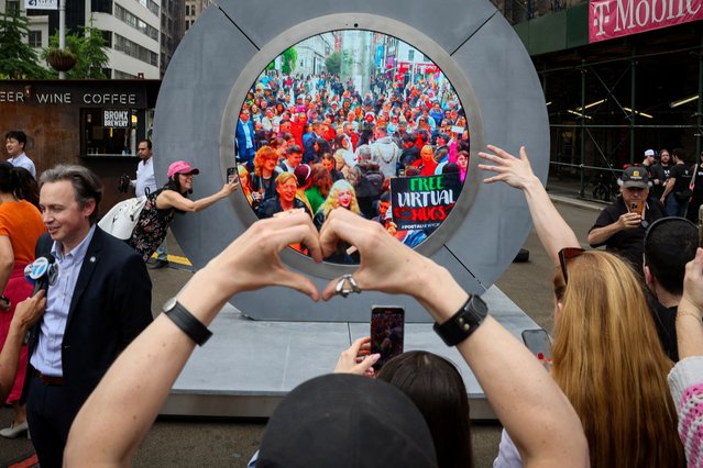 New Yorkers greet people in Dublin during the reveal of The Portal, a public technology sculpture that links with direct connection between Dublin, Ireland and the Flatiron district in Manhattan, in New York City on May 8, 2024. (Photo by Brendan McDermid/Reuters)