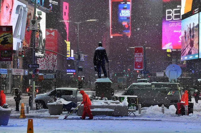 Men plow snow in Times Square during a snowstorm in New York on March 14, 2017. (Photo by Jewel Samad/AFP Photo)