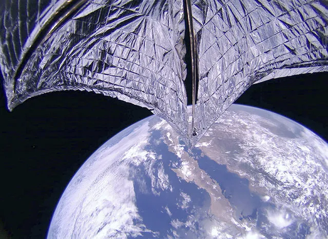 This photo provided on Thursday, July 25, 2019, by the Planetary Society shows a portion of the LightSail2 spacecraft, top, and part of Earth, centered on Baja California, Mexico. It was one of the photos transmitted from The Planetary Society's LightSail 2 spacecraft, confirming the successful deployment of its solar sail. (Photo by Planetary Society via AP Photo)