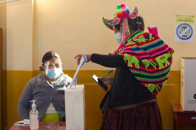 A Quechua indigenous woman dressed in typical ethnic attire casts her vote at a polling station in the remote rural village of Capachica, in Puno, peru, close to the border with Bolivia, during general elections on April 11, 2021. Some 25 million Peruvians are set to turn out to vote for a new president and 130 members of the unicameral congress amid the countrys deadliest week of the coronavirus pandemic and a surge in new infections. (Photo by Juan Carlos Cisneros/AFP Photo)