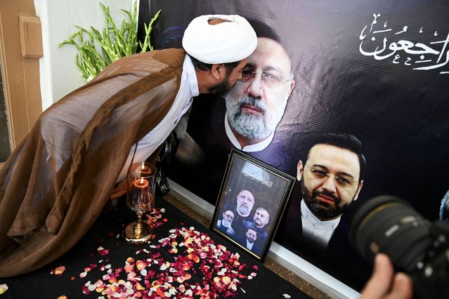 A man kisses the portrait of Iranian president Ebrahim Raisi who died in a helicopter crash, during a condolence ceremony held at Iranian Cultural center in Peshawar on May 21, 2024. Pakistan's Prime Minister Shehbaz Sharif declared a day of mourning after Iranian media reported that president Ebrahim Raisi had died in a helicopter crash. (Photo by Abdul Majeed/AFP Photo)