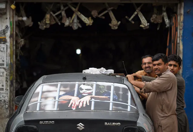 Motor mechanics look on as they decorate a car at their workshop on the outskirts of Islamabad on August 26, 2019. Analysts warn that with Pakistan's galloping population increase far outstripping growth – set to slow to 2.4 percent this year – the country will find no short-term relief, even after the International Monetary Fund approved its latest $6 billion loan. (Photo by Farooq Naeem/AFP Photo)