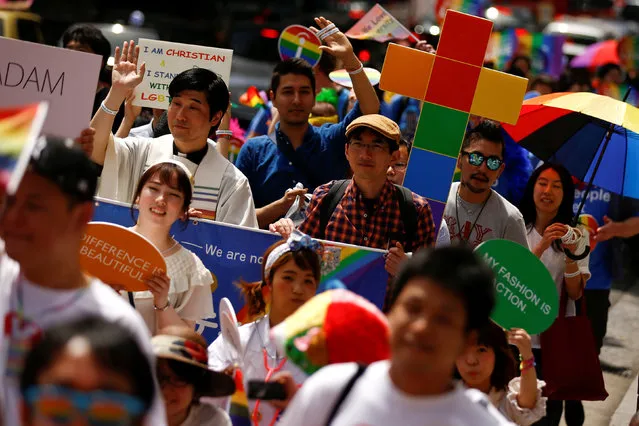 A man holds a Christian cross in the rainbow colours during the Tokyo Rainbow Pride parade celebrating lesbian, gay, bisexual, and transgender (LGBT) culture in Tokyo, Japan, May 8, 2016. (Photo by Thomas Peter/Reuters)