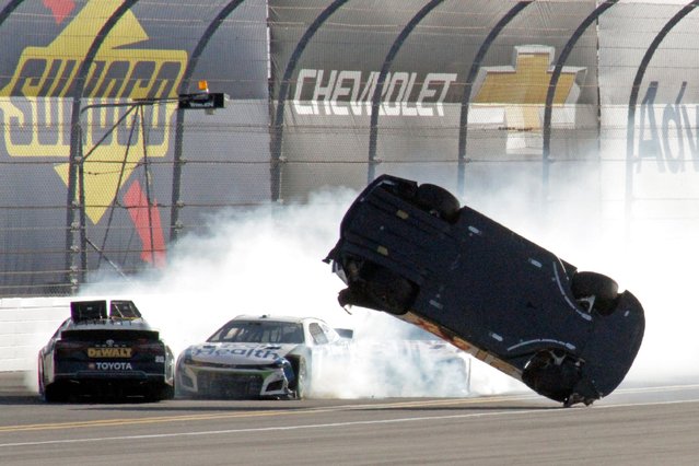 Harrison Burton, right, flips as he wrecks on the backstretch as Christopher Bell, left, and Ross Chastain try but are unable to avoid the crash during the NASCAR Daytona 500 auto race at Daytona International Speedway, Sunday, February 20, 2022, in Daytona Beach, Fla. (Photo by Chuck McQuinn/AP Photo)