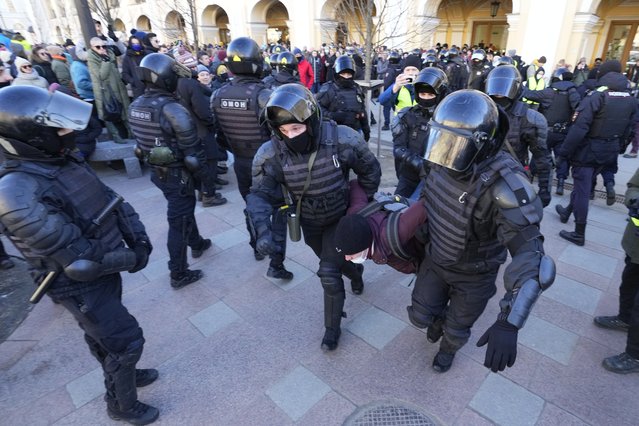 Police detain a demonstrator during an action against Russia's attack on Ukraine in St. Petersburg, Russia, Sunday, February 27, 2022. Protests against the Russian invasion of Ukraine resumed on Sunday, with people taking to the streets of Moscow and St. Petersburg and other Russian towns for the third straight day despite mass arrests. (Photo by Dmitri Lovetsky/AP Photo)
