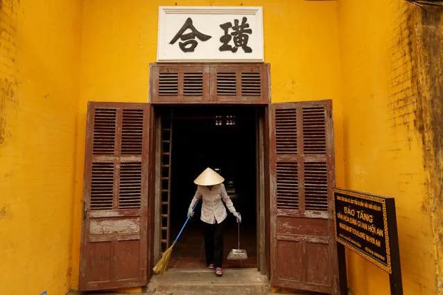A woman wearing a traditional hat, known as a non la, sweeps an entrance of a museum in Hoi An, Vietnam April 5, 2016. (Photo by Jorge Silva/Reuters)
