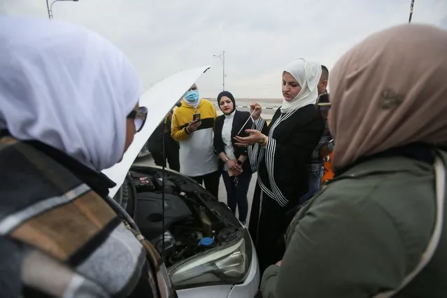 Noura Al Ali, 29, a female driving instructor, checks car engine oil as teaches a woman to drive in a male-dominated sector, in Basra, Iraq, February 11, 2022. (Photo by Essam al-Sudani/Reuters)