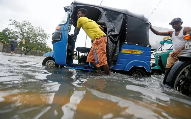 A man pushes his trishaw after it got stuck on a flooded road during a wet day in Colombo, Sri Lanka May 16, 2016. (Photo by Dinuka Liyanawatte/Reuters)