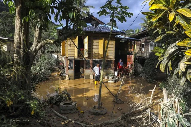 A couple cleans their home covered in mud after the flooding a day earlier at Kuala Langat, 15KM from KuaLumpur, Malaysia, 20 December 2021. Several Malaysian states has been struck by floods caused by two days of heavy rain leaving five killed and 41,000 of residents to be evacuated with many trapped in their vehicles and homes. (Photo by Fazry Ismail/EPA/EFE)