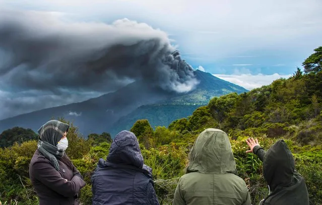 People look at the Turrialba volcano as it spewes ashes on May 20, 2016, in Cartago, Costa Rica. The Turrialba volcano started erupting columns of smoke and ash that the wind extended towards the Costa Rican capital, in what according to experts is the strongest eruption in the past six years. (Photo by Ezequiel Becerra/AFP Photo)