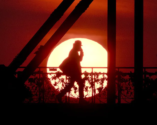 The sun rises behind the “Eiserne Steg” (Iron Footbridge) pedestrian bridge in Frankfurt, Germany, early Tuesday, April 2, 2019. (Photo by Michael Probst/AP Photo)