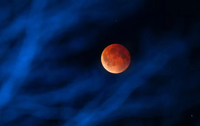 The moon glows a red hue during a total lunar eclipse Tuesday, April 15, 2014, as seen from the Milwaukee area. Tuesday's eclipse is the first of four total lunar eclipses that will take place between 2014 to 2015. (Photo by Mike De Sisti/AP Photo/Milwaukee Journal-Sentinel)