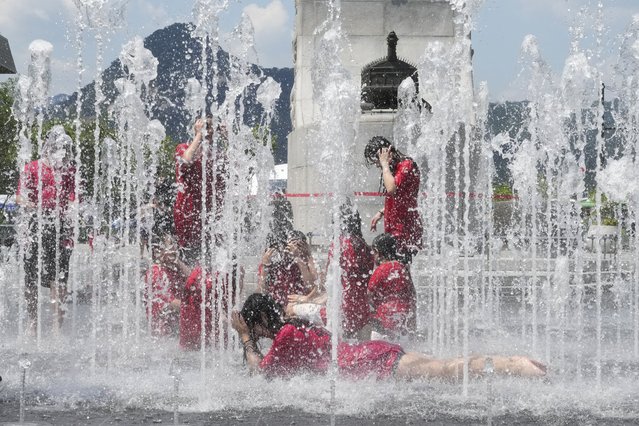 Gangsol elementary school students cool themselves off in a public fountain in Seoul, South Korea, Wednesday, June 26, 2024. South Korean Meteorological Administration forecasted temperatures at 30 degrees Celsius (86 degrees Fahrenheit) in Seoul. (Photo by Ahn Young-joon/AP Photo)