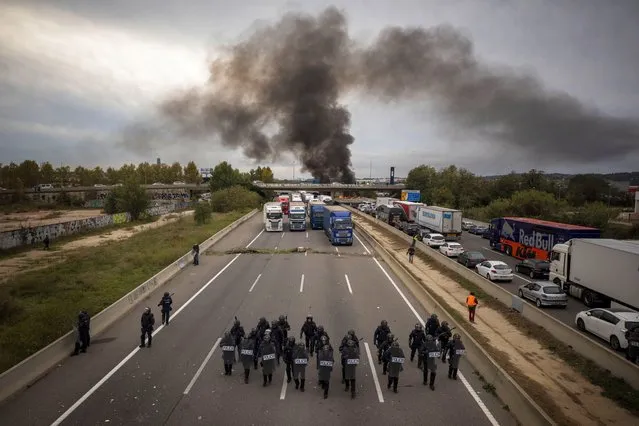 National police disperse pro-independence demonstrators blocking a major highway near Girona, Spain, Wednesday, November13, 2019. Hundreds of car and truck drivers were stuck Wednesday in a large traffic jam in northeastern Spain caused by Catalan separatists blocking a major highway near the city of Girona. (Photo by Emilio Morenatti/AP Photo)