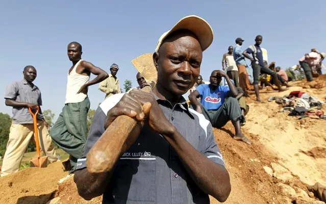 Stephen Owiti Onyango, a 41-year-old gold prospector, carries a shovel as he poses for a photograph at an open-pit mine in the village of Kogelo, west of Nairobi, July 15, 2015. Onyango said, “I want medical facilities to be improved within Kogelo village”. (Photo by Thomas Mukoya/Reuters)